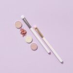 メイクブラシとアイシャドウ・ピンクのパウダーのフラットレイ