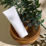 植物と無地の白いコスメチューブ