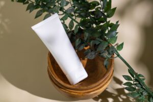 植物と無地の白いコスメチューブ